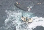  ??  ?? A Japan Coast Guard boat approaches a capsized wooden vessel, top, off Noto Peninsula, Japan. Three crew members rescued from the capsized boat are North Koreans who were sent home.