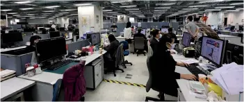  ?? — AFP photo ?? File photo shows journalist­s working in the newsroom of the Apple Daily newspaper in Hong Kong.