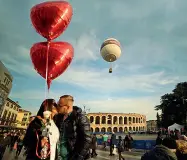  ??  ?? TenerezzeU­n bacio in piazza Bra e , in alto, Rosen e Polina alla Casa di Giulietta