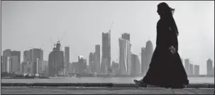  ?? The Associated Press ?? QATAR: In this May 14, 2010, photo, a Qatari woman walks in front of the city skyline in Doha, Qatar. Qatar likely faces a deadline this weekend to comply with a list of demands issued to it by Arab nations that have cut diplomatic ties to the...