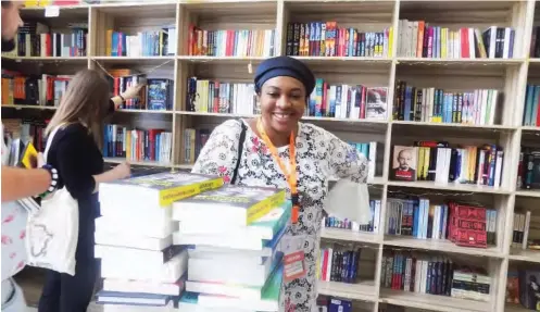  ??  ?? A participan­t poses before her books at the festival bookstore