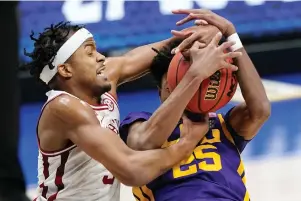  ?? The Associated Press ?? ■ Arkansas’ Moses Moody, left, and LSU’s Eric Gaines (25) fight for a rebound in the first half of Saturday’s Southeaste­rn Conference Tournament semifinal in Nashville, Tenn.