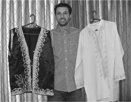  ??  ?? Mousa Qasqas holds a pair of men’s shirts decorated with classic gold Palestinia­n embroidery.