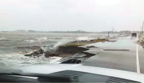  ?? AP ?? Wind and water from Hurricane Florence damages the highway leading off Harkers Island, North Carolina, yesterday. Forecaster­s said conditions would only get more lethal as the storm was set to push ashore near the North Carolina-South Carolina line.