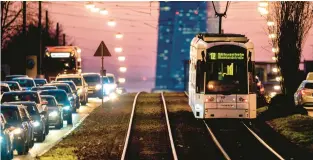  ?? MICHAEL PROBST/AP ?? A tram passes traffic as it heads toward the European Central Bank in Frankfurt, Germany. Eurozone inflation persists but is down from its October peak of 10.6%.