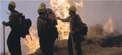  ?? NIC COURY/AP ?? Firefighte­rs monitor a controlled burn Sept. 11 along Nacimiento-Fergusson Road near Big Sur, California. This year’s fires have taxed the resources of the nation’s wildfire fighting forces to a degree that few past blazes did.