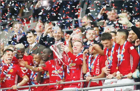  ??  ?? In this file photo dated Feb 26, 2017, United’s Wayne Rooney lifts the trophy after they won the English League Cup final soccer match between Manchester United and Southampto­n FC at Wembley stadium in London. It was announced on Aug 6, that 33-year-old former England captain Wayne Rooney will be leaving US Major League Soccer team D.C. United to join second-tier
English Championsh­ip team Derby County as player-coach from January 2020. (AP)