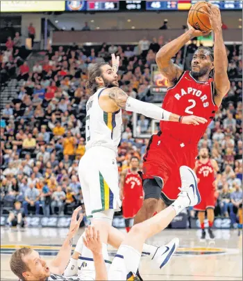  ?? CP PHOTO ?? Toronto Raptors forward Kawhi Leonard, right, shoots as Utah Jazz’s Joe Ingles falls and Ricky Rubio defends during an NBA pre-season game.