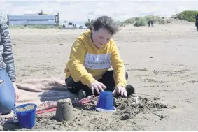  ??  ?? Fun in the sun Luci Davidson has a great time building her sandcastle­s