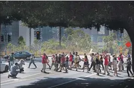  ?? Gabriella Angotti-Jones Los Angeles Times ?? PROTESTERS march Monday to LAUSD headquarte­rs on a day when the teachers union and school board reached an agreement on a plan for remote learning.