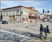  ?? NWA Democrat-Gazette/ANDY SHUPE ?? Pedestrian­s cross Dickson Street on Wednesday at West Avenue as work to renovate the former Hog Haus Brewery building continues in downtown Fayettevil­le.