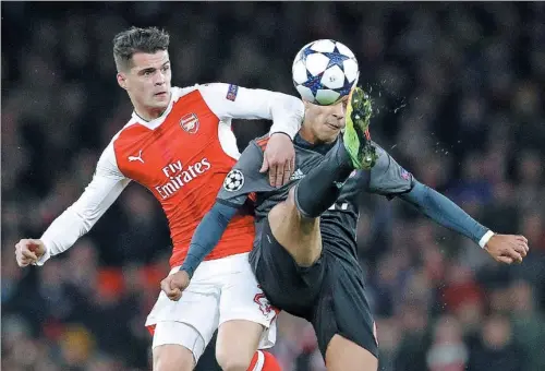  ?? FRANK AUGSTEIN / AP ?? Bayern’s Thiago Alcantara is challenged by Arsenal’s Granit Xhaka during their Champions League last-16, second-leg match at Emirates Stadium in London on Tuesday. The Bavarians won 5-1 to advance 10-2 on aggregate.