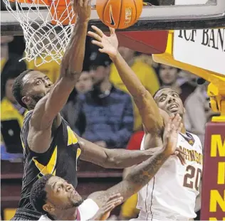  ?? | AP ?? Minnesota’s Austin Hollins (20) battles for a rebound Tuesday. He scored a career-high 27 points.