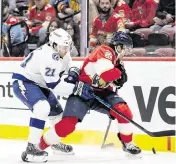  ?? MATIAS J. OCNER mocner@miamiheral­d.com ?? Panthers forward Ryan Lomberg and Tampa Bay’s Brayden Point fight for possession of the puck along the boards during the first period Monday at FLA Live Arena.