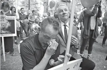  ?? AP Photo/Rick Bowmer ?? ■ Robin Day of Arkansas cries as hundreds of Mormons and ex-Mormons gather before marching to the church’s headquarte­rs Friday in Salt Lake City. The group of about 1,000 people delivered petitions demanding an end to one-on-one interviews between...