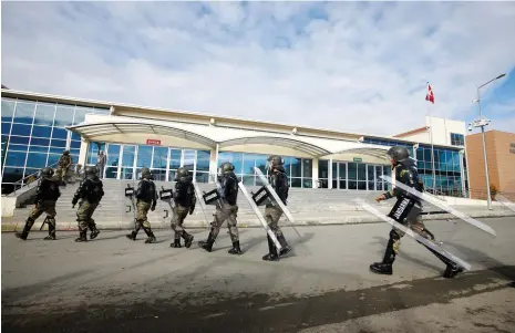  ?? (Osman Orsal/Reuters) ?? TURKISH SOLDIERS walk outside Istanbul’s Silivri prison and courthouse complex yesterday during the first trial related to Turkey’s failed coup.