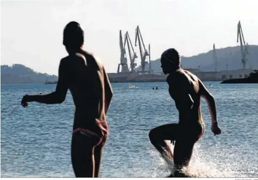  ?? KIKO DELGADO / EFE ?? Miembros del club de natación Marina Ferrol entrenando el viernes en la playa de Caranza de Ferrol.