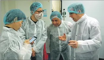  ?? 06_a38LFO_Chinese04 ?? Richard Hunt-Smith, right, explains the salmon curing process.