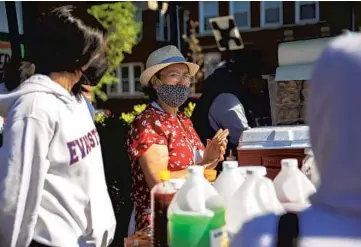  ?? ERIN HOOLEY/CHICAGO TRIBUNE ?? Zenaida Castillo serves customers Wednesday at her family’s food stand in the Rogers Park neighborho­od. Her husband, Felipe Vallarta, got sick with COVID-19 a few days before he was scheduled to receive the vaccine.