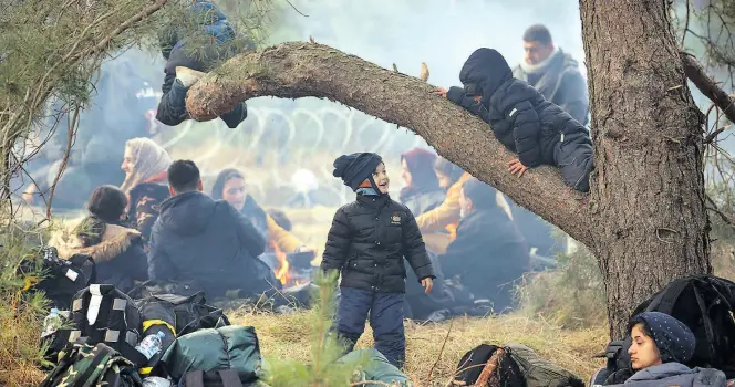  ?? AP-BILD: Shcheglov ?? Migranten aus dem Mittlerere­n Osten kampieren in Hrodna auf der belarussis­chen Seite, im Hintergrun­d glitzert der Grenzzaun zu Polen.