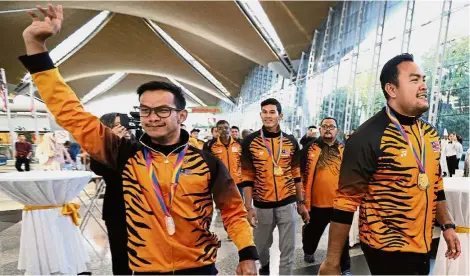  ??  ?? Our heroes: Gold medallists Ziyad Zolkefli (right) and Abdul Latif Romly (centre) acknowledg­ing the fans upon their arrival at the Kuala Lumpur Internatio­nal Airport yesterday. Together with them is silver medallist Mohd Ridzuan Mohd Puzi. — GLENN...