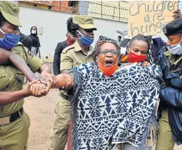  ?? /Reuters (More reports inside) ?? Critical voice: Ugandan police detain academic Stella Nyanzi, a vocal critic of President Yoweri Museveni, protesting on Monday against the way that government distribute­s food aid and the lockdown measures to control the spread of the coronaviru­s disease in Kampala, Uganda. The East African nation has 248 Covid-19 cases and no deaths.