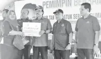  ??  ?? Zakaria (third right) presenting the plaque of hawker kiosk plaque to one of the recipients.