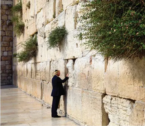  ?? Foto: Ronen Zvulun, afp ?? Ganz ohne Gefolge hielt US Präsident Donald Trump an der Klagemauer in Jerusalem inne. Er legte seine rechte Hand in eine der tiefen Spalten der Mauer, die als heiliger Ge betsort der Juden weltberühm­t ist.