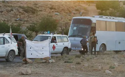  ??  ?? Lebanese Red Cross and Hezbollah fighters are seen escorting buses in Jroud Arsal, Lebanon in August.