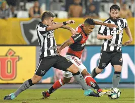  ??  ?? Berrío, do Fla, tenta passar pela marcação de Victor Luís, do Botafogo