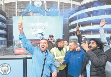  ?? — Gambar AFP ?? RAIKAN BERSAMA: Penyokong Manchester City berkumpul di luar Stadium Etihad bagi meraikan kejayaan pasukan mereka memenangi Kejuaraan Liga Perdana Inggeris.