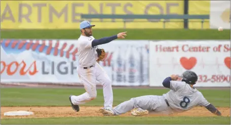  ?? PHOTOS BY BERT HINDMAN ?? Blue Crabs shortstop Steve Lombardozz­i pivots and throws to first while avoiding the slide from Bridgeport’s Rafael Lopez in the second game of Wednesday’s doublehead­er at Regency Furniture Stadium in Waldorf. The Blue Crabs won the finale of the...