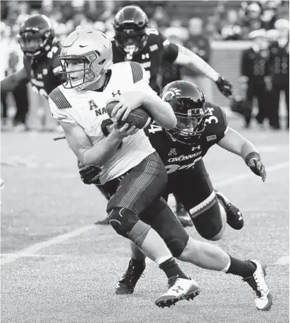  ?? JOHN MINCHILLO/ASSOCIATED PRESS ?? Navy’s Zach Abey, who made his first start of the season at quarterbac­k, gets tackled by Cincinnati linebacker Kyle Bolden.