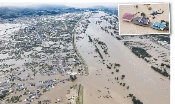  ?? Picture: KYODO NEWS VIA AP) ?? Homes are submerged after an embankment of the Chikuma River broke in Nagano, where helicopter­s were plucking residents to safety (inset).