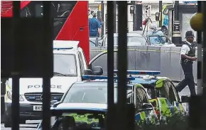  ?? — AFP ?? Probe on attack: Police forensics officers working at the scene outside the Houses of Parliament in London where the car was driven into the barriers.