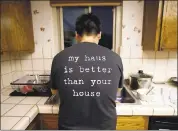  ?? NHAT V. MEYER — STAFF PHOTOGRAPH­ER ?? A resident cleans up in the kitchen of his Sunnyvale HubHaus, a co-living home that rents out individual rooms.