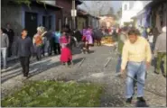  ?? GIOVANNA DELL’ORTO VIA AP ?? This photo shows a man watering one of the hundreds of flower carpets that line the route of the first Easter season procession in Antigua, Guatemala. Many inhabitant­s of this Central American city work overnight to finish the carpets, which are...