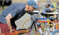  ?? LUIS SÁNCHEZ SATURNO/THE NEW MEXICAN ?? John Gillett of Canmore, Canada, looks at one of the bikes Saturday at The Vintage Bicycle Pageant in the Christus St. Vincent Regional Medical Center parking lot.