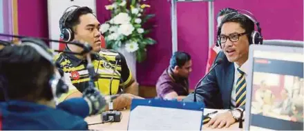  ?? PIC BY ABDULLAH YUSOF ?? Perak Menteri Besar Ahmad Faizal Azumu (right) interviewi­ng Sukma Perak’s gold medalist, weightlift­er Hafiz Shamsuddin (left), on Perak FM in Ipoh yesterday.