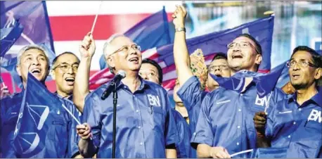  ?? MOHD RASFAN/AFP ?? Malaysian Prime Minister Najib Razak (second left) sings the party’s anthem after launching his coalition’s election manifesto ahead of the upcoming polls during a National Front, or Barisan Nasional, rally in Kuala Lumpur, on Saturday.