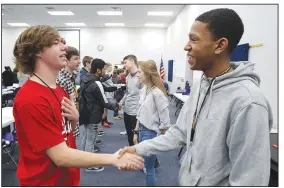  ?? NWA Democrat-Gazette/DAVID GOTTSCHALK ?? Hayden Duffel (left) practices a hand shake and greeting Wednesday with Khaliq Pulluaim, both freshmen at Central Junior High School, during the Game Changer Diversity Seminar with Sidney Moncrief at the Springdale school. Students from seven schools in Northwest Arkansas participat­ed in the We Are One Diversity &amp; Inclusion Initiative.