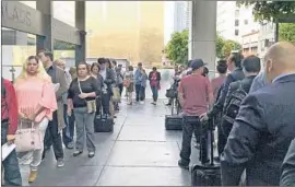  ?? Amy Taxin Associated Press ?? IMMIGRANTS WAITING for deportatio­n hearings line up last month outside the building that houses the federal immigratio­n courts in downtown Los Angeles.