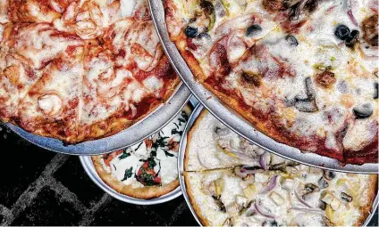  ?? Photos by Mike Sutter / Staff ?? Pizza choices include, clockwise from top left, shrimp, Supreme, chicken Alfredo and margherita at Capparelli's on Main.