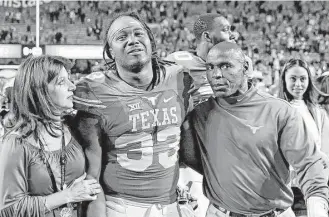  ?? Joshua Guerra / The Daily Texan ?? Despite a 2,000-yard rushing season from D’Onta Foreman (33), Charlie Strong and his tailback walk off the field Friday with a 5-7 record after a 31-9 loss to TCU that ended the coach’s UT stint.