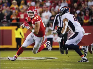  ?? ED ZURGA — THE ASSOCIATED PRESS ?? Kansas City Chiefs tight end Travis Kelce (87) catches a pass as Denver Broncos linebacker Kenny Young defends during the first half of an NFL football game Sunday in Kansas City, Mo.