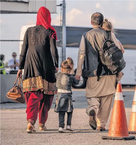  ?? REUTERS ?? Afghan refugees who supported Canada’s mission in Afghanista­n prepare to board buses after arriving at Toronto Pearson Internatio­nal Airport on Tuesday.