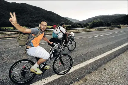  ?? PHOTO: OGNEN TEOFILOVSK­I ?? RACING TO BE FREE: Migrants from Syria ride their bicycles near the Greek border in Macedonia. Hungary announced plans on Wednesday to build a four-metre-high fence along its border with Serbia to stem the flow of illegal migrants, many of whom use...