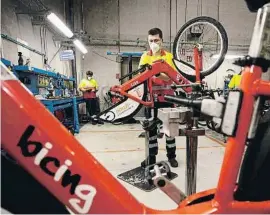  ??  ?? Un operario instalando el kit eléctrico a una bici mecánica