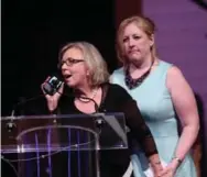  ?? FRED CHARTRAND/THE CANADIAN PRESS FILE PHOTO ?? Green party Leader Elizabeth May gets a helping hand offstage from Transport Minister Lisa Raitt recently at the press gallery dinner.