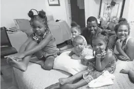  ?? RICARDO RAMIREZ BUXEDA/ORLANDO SENTINEL ?? Dexter and Jocelyn Bennett, with their five children, at a HomeTowne Studios by Red Roof, are pictured on April 13. The family is living in a pay-by-the-week hotel after getting evicted from their home in March 2020.